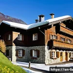 리히텐슈타인에서의 숙박 옵션 - A cozy alpine inn nestled in the snow-covered mountains of Liechtenstein, showcasing traditional woo...